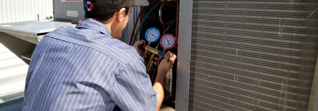 HVAC technician servicing a condenser unit in Perkiomen