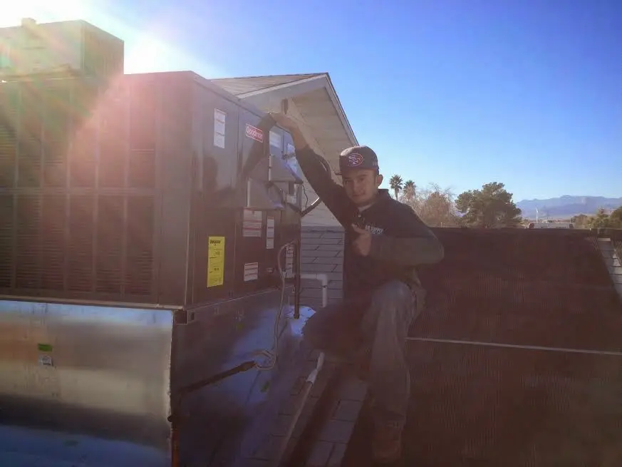 HVAC technician performing Heat Pump Repair on a rooftop unit in Perkiomen